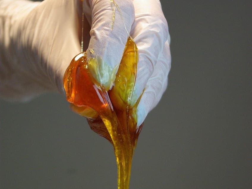 Warm golden sugar paste stretched by hand — the sugaring technique used at Harav